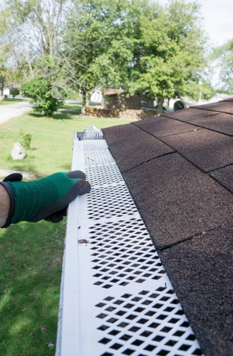 gutter guard with green glove in shot